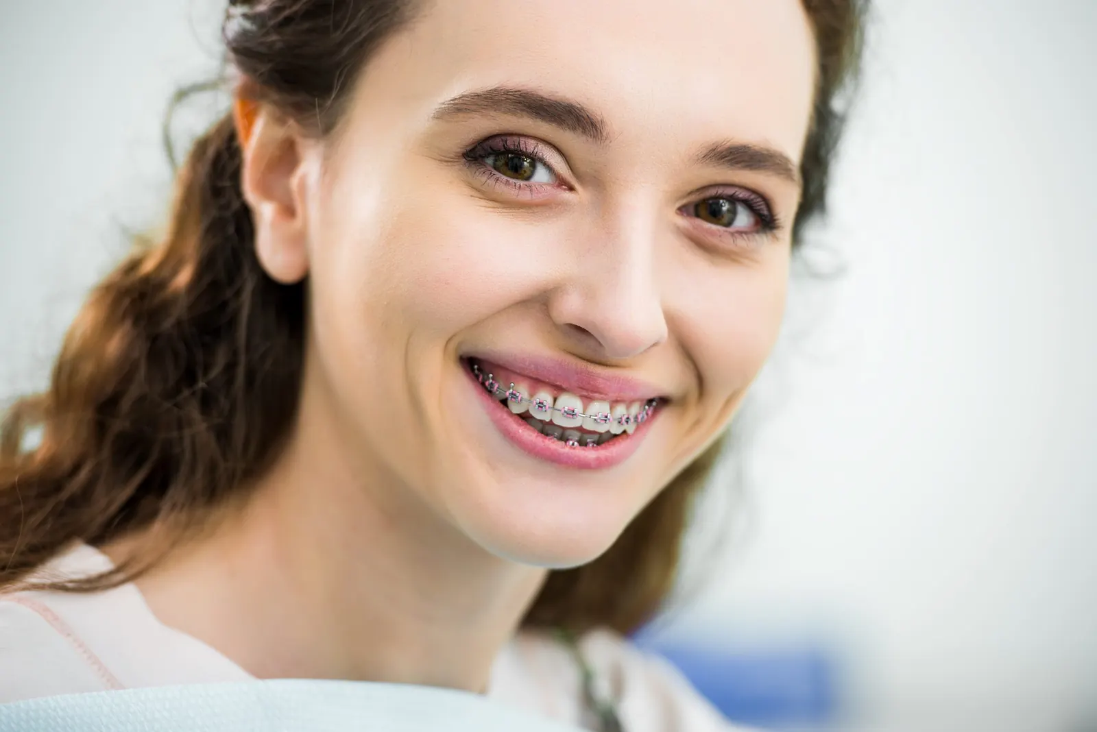 Adult patient smiling with braces at Superior Orthodontics in Metro Detroit, MI