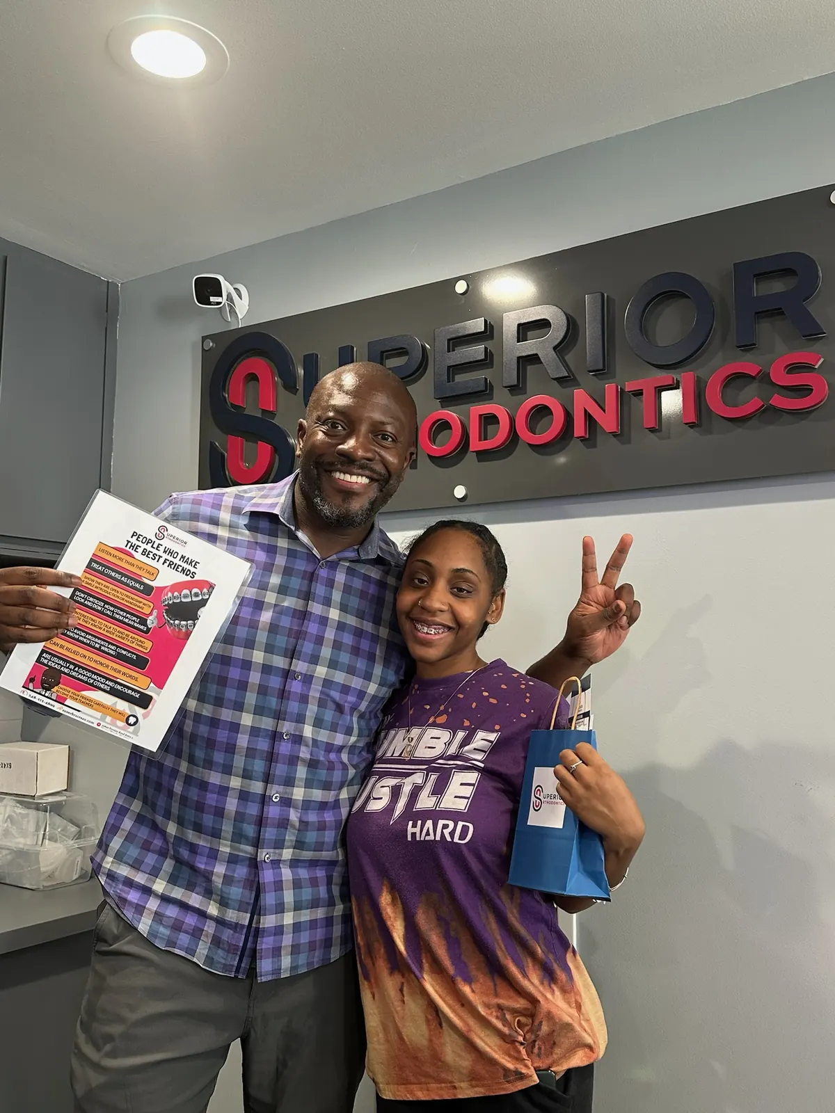 Dr. Kishawn Kole-James with a patient under the Superior Orthodontics office sign in Eastpointe, MI