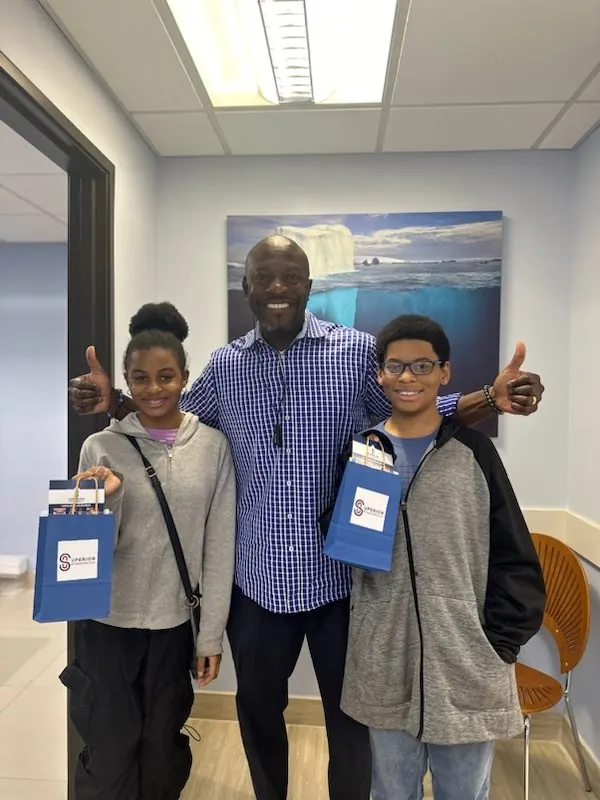 Dr. Kishawn Kole-James with two patients giving thumbs up at Superior Orthodontics