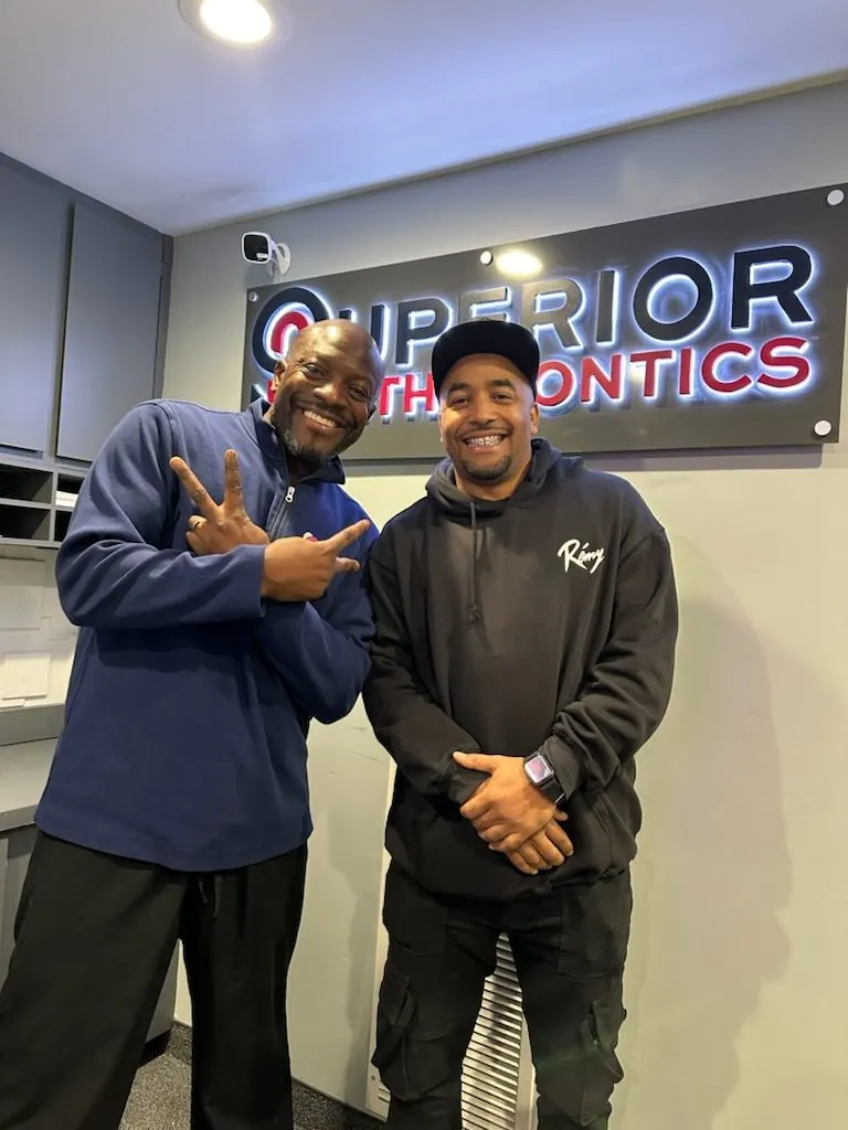 Dr. Kishawn Kole-James with a patient under the Superior Orthodontics sign