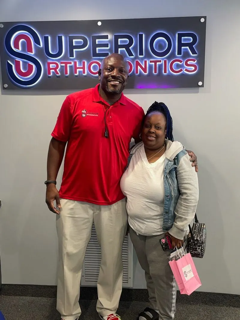 Dr. Kishawn Kole-James with a patient holding the Superior Orthodontics pink gift bag